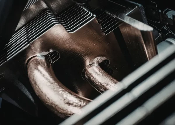 Close-up of a custom copper heat sink with integrated heat pipes and fin structure for advanced thermal management in high-performance electronics