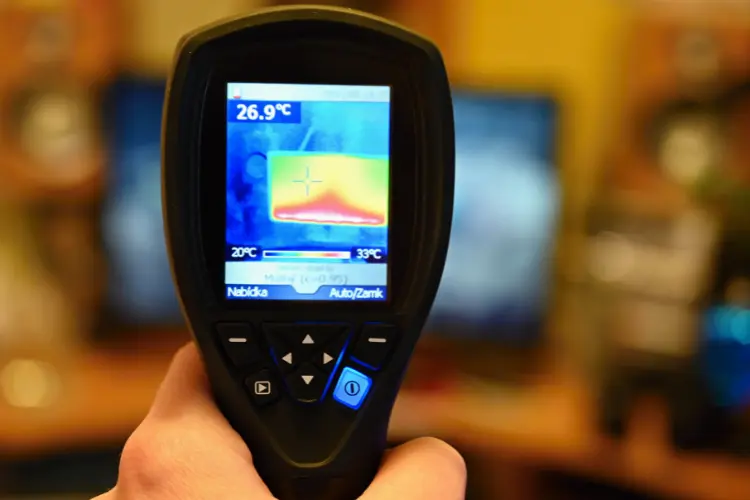 Handheld thermal imaging camera measuring heat distribution in electronic hardware during thermal validation testing