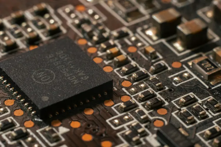 Microchip mounted on dense circuit board representing high-density electronics and overheating prevention